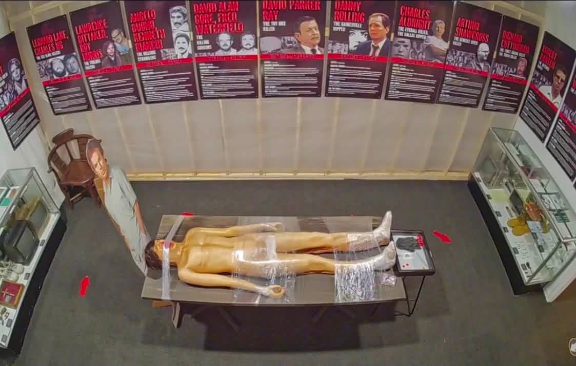 An overhead view of the Dexter Room — the kill-table centerpiece flanked by the artifact display cases